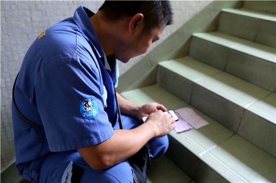 客戶還是沒有到，家具安裝謝師傅蹲在門口等，一邊等一邊處理今天要去的下一家客戶的資料