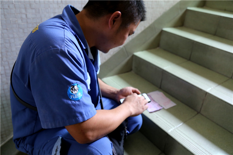 客戶還是沒有到，家具安裝謝師傅蹲在門口等，一邊等一邊處理今天要去的下一家客戶的資料