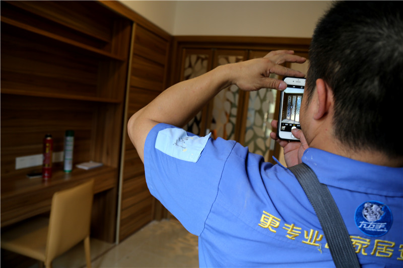 謝師傅看著安裝好的家具，拍下照片