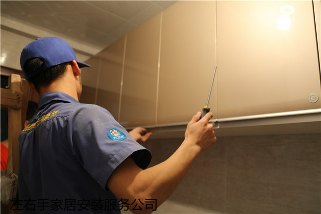 櫥柜安裝師傅正在檢查吊柜門(mén)板